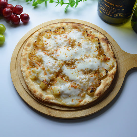 斜め上から撮影された生姜ソースにモッツァレラチーズ、鶏ミンチ、じゃがいもがトッピングされているローマ風ピザ